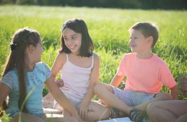 happy-kids-sitting-grass-outside