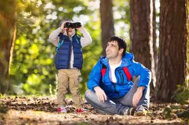 boy-using-binoculars-woods