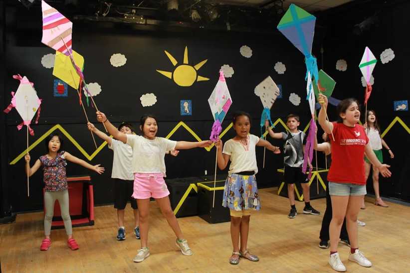 ChatGPT said:
Kids indoors holding colorful kites, joyfully stretching arms wide in a playful, decorated room with sun and clouds on the wall.